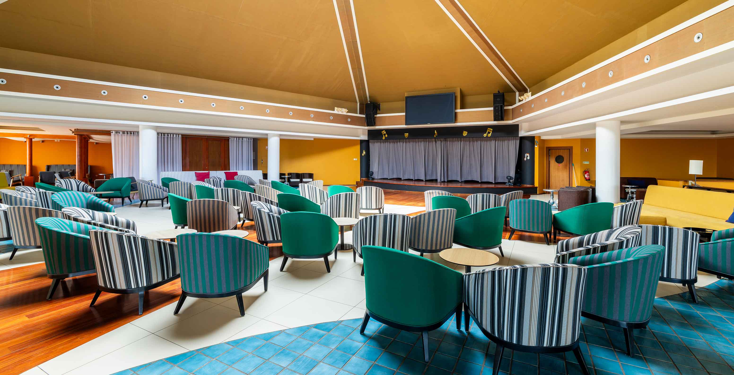 Bar do Pestana Porto Santo, Hotel com Tudo Incluído e Spa no Porto Santo, com poltronas coloridas e palco ao fundo