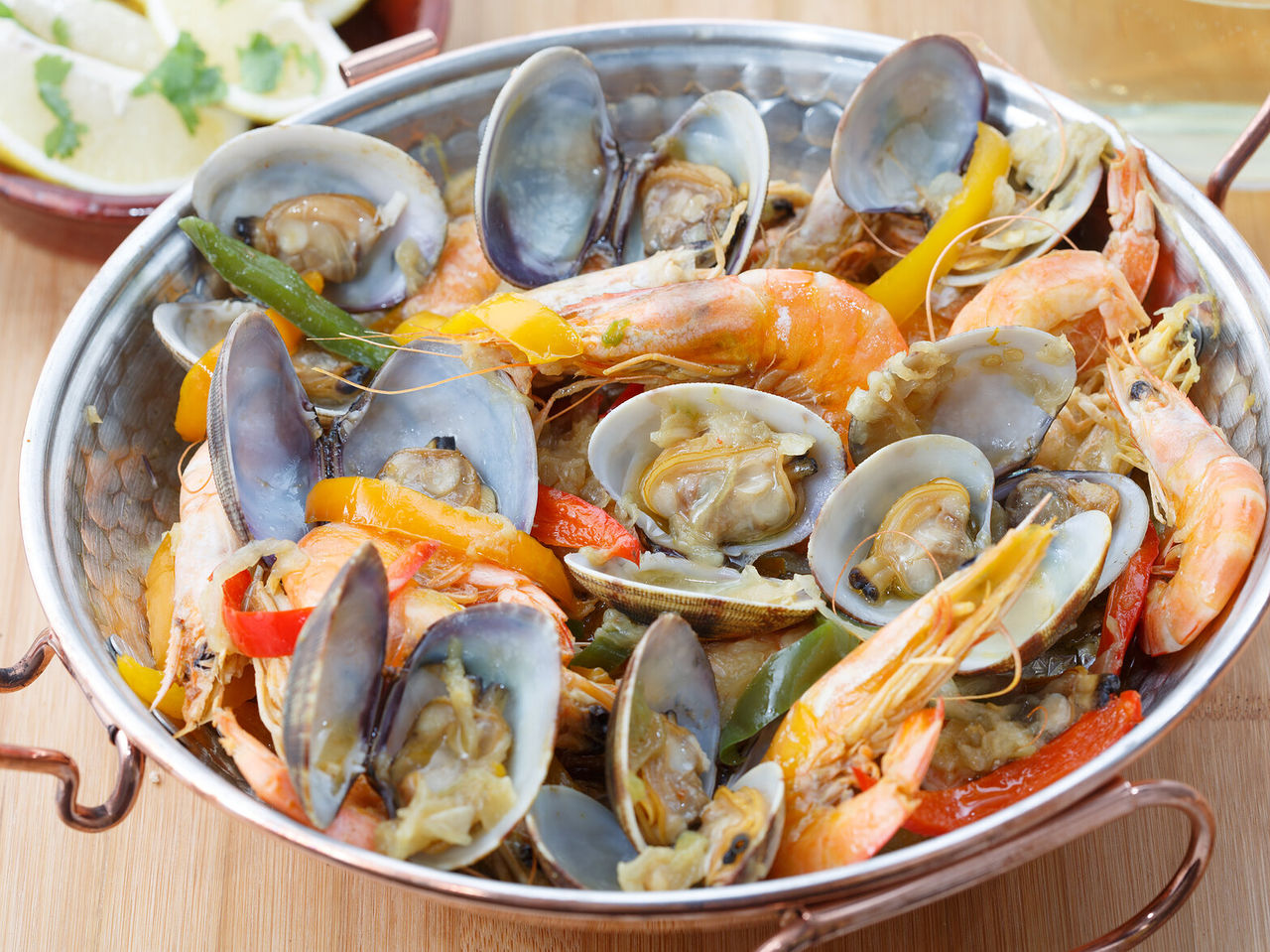 Traditioneel gerecht uit de Algarve-regio, een zeevruchten cataplana met mosselen, garnalen en paprika, met citroen