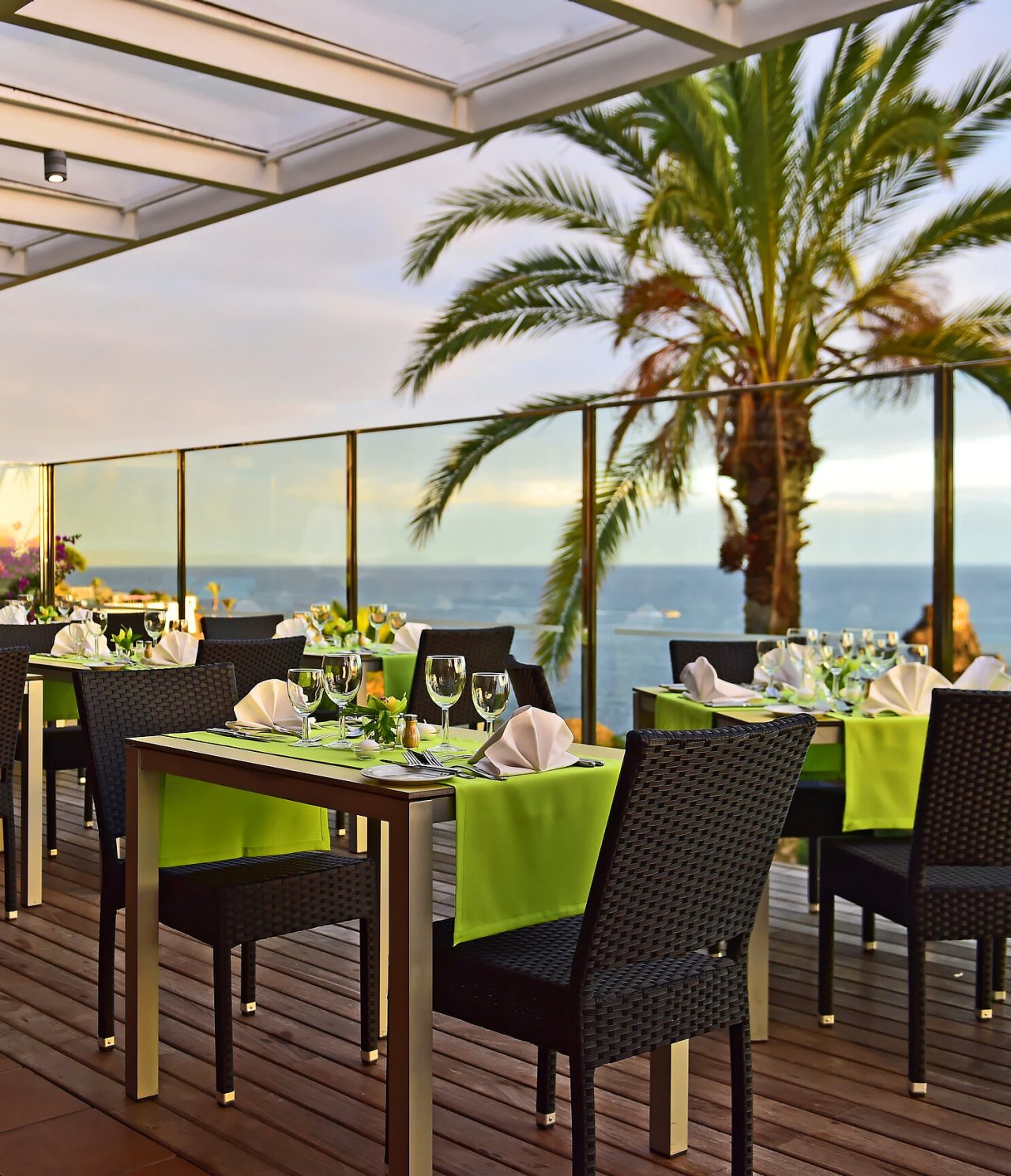 Het restaurant The Deck, van het hotel aan zee in Funchal, heeft verschillende tafels met groene tafellakens