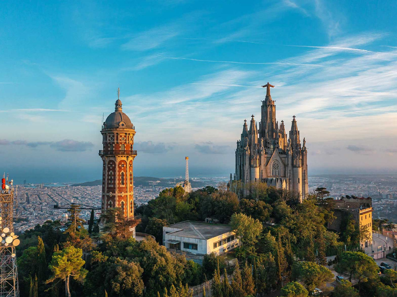 Uitzicht op de Tempel van het Heilig Hart van Jezus op Tibidabo, omgeven door vegetatie met Barcelona op de achtergrond