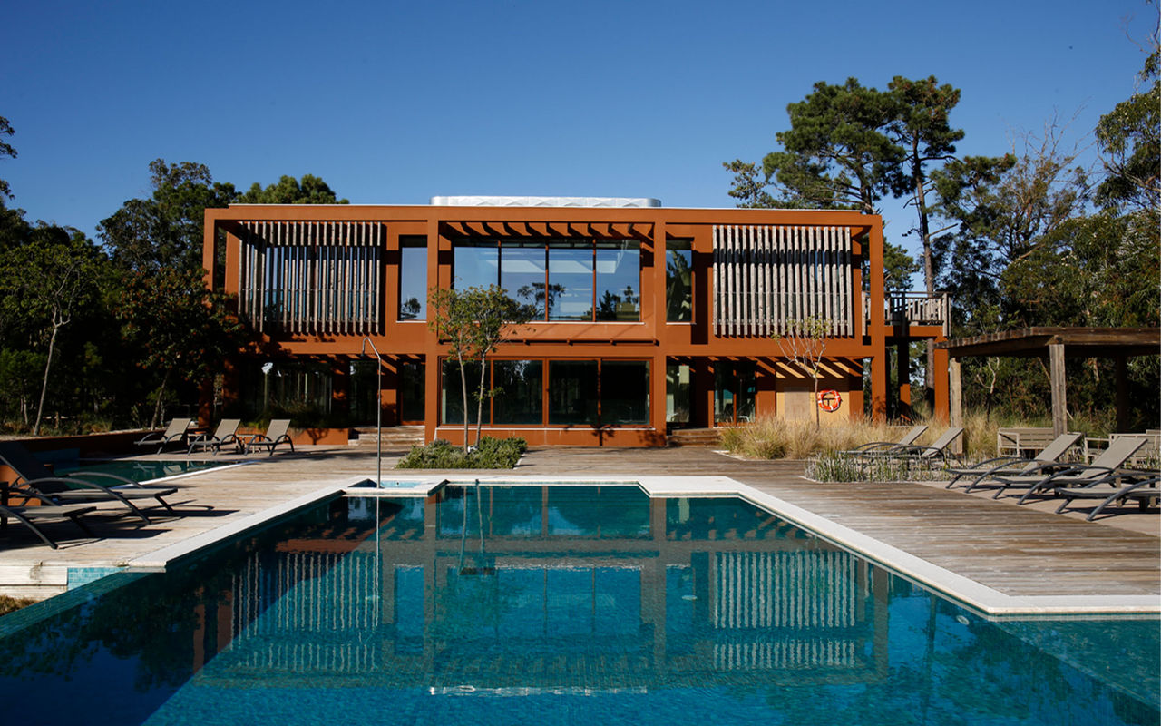 Villas met buitenzwembad en ligstoelen, in Eco Resort in Portugal, behorend tot het merk Pestana Residences