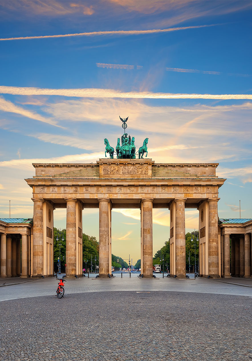 View of the Brandenburg Gate in Berlin on a clear day with few clouds and a bicycle in the middle of the pavement