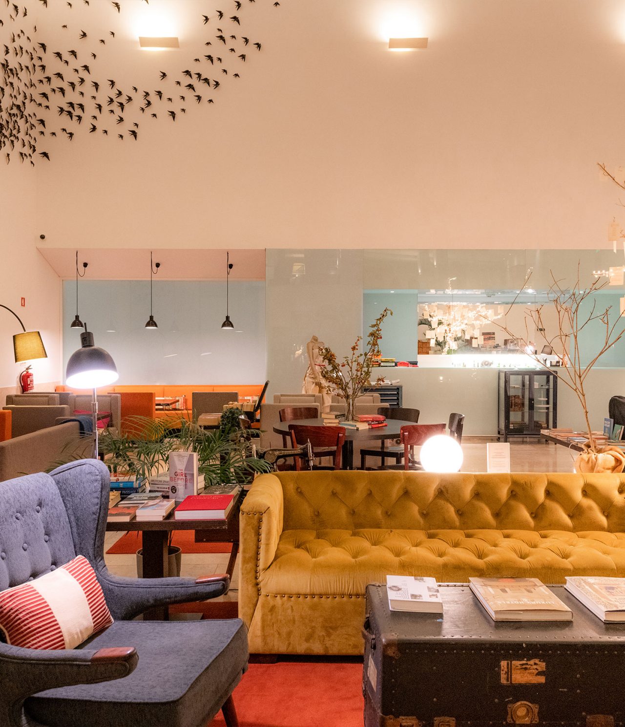 Restaurant The Chapter in a 5-Star Hotel in Cascais, has a yellow sofa, gray armchair, and table