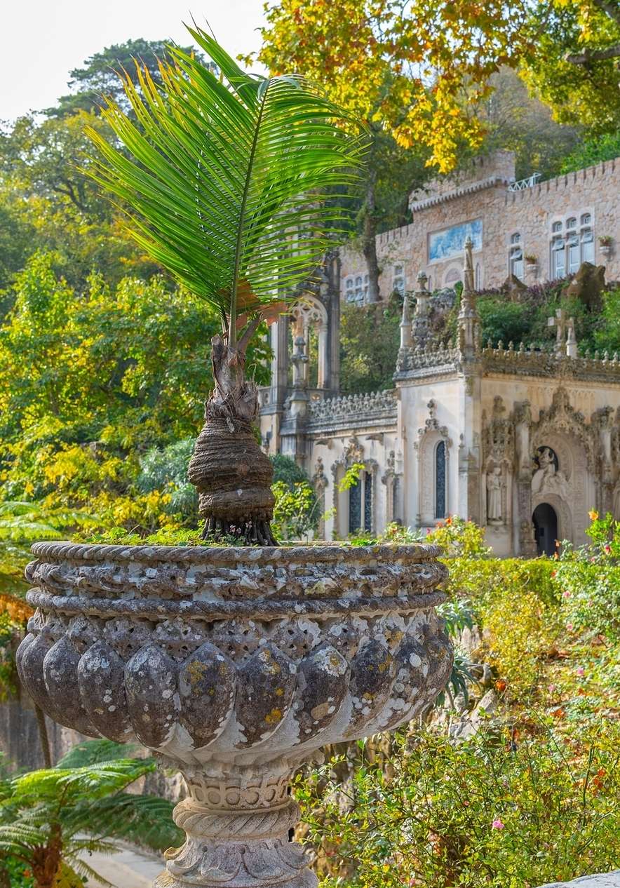 Quinta da Regaleira in Sintra with a facade adorned with gothic and romantic elements surrounded by intense green vegetation