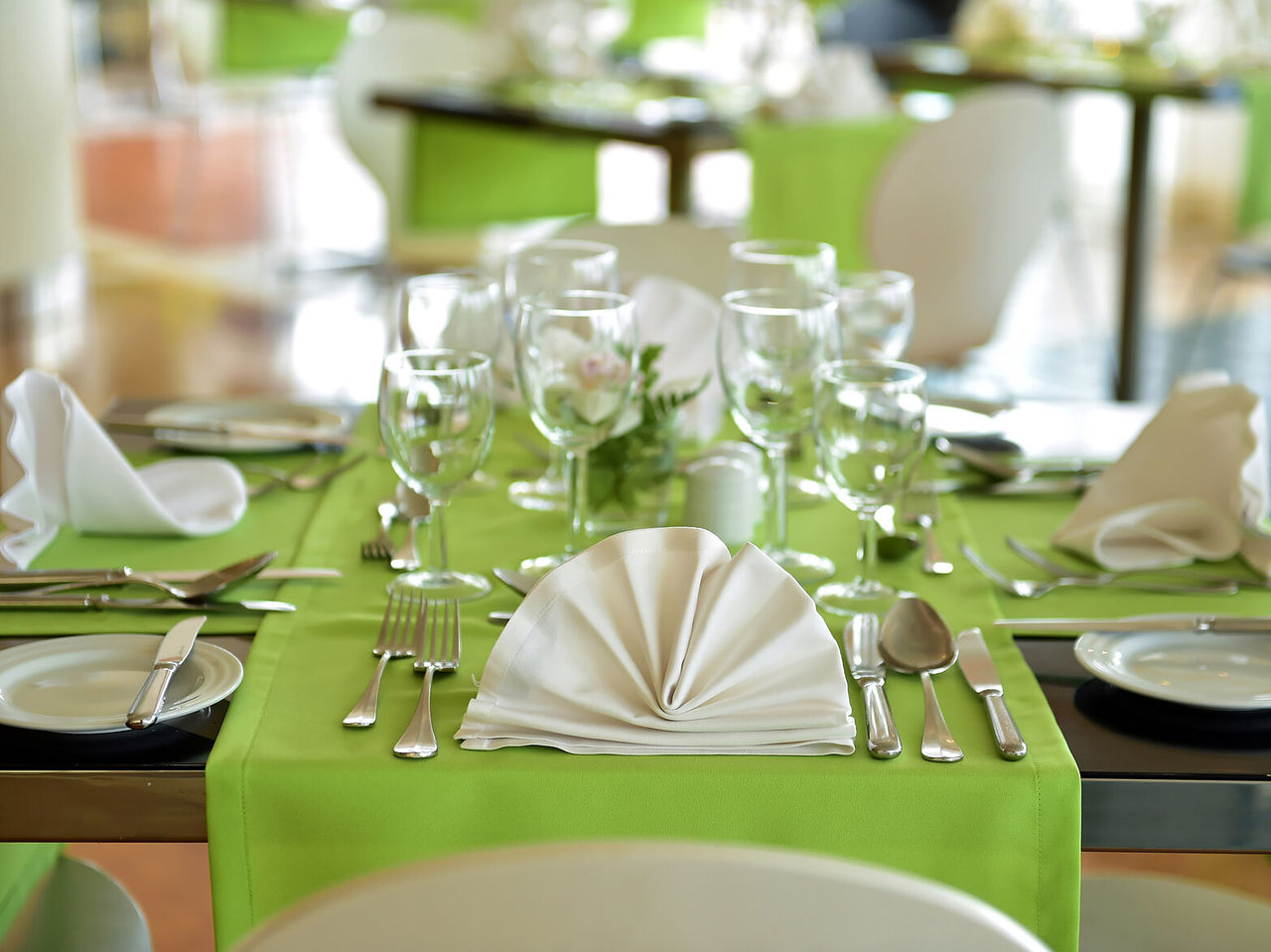 The Breezes Restaurant, at a 4-Star Hotel by the Sea in Funchal, has elegant tables with green tablecloths