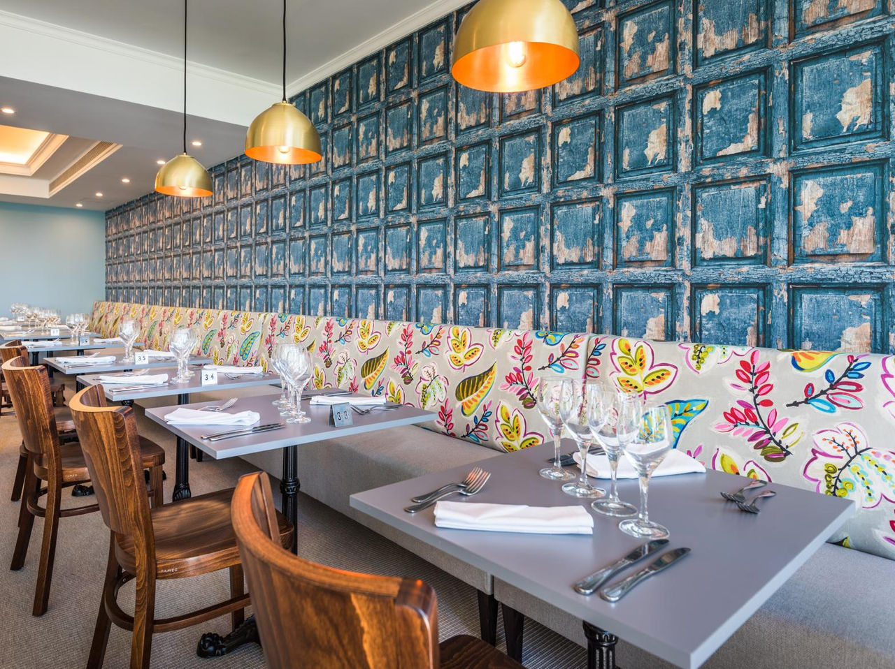 The Campo de Fiori restaurant, at the 5-Star Hotel in Funchal, has a colorful wall and tables and chairs