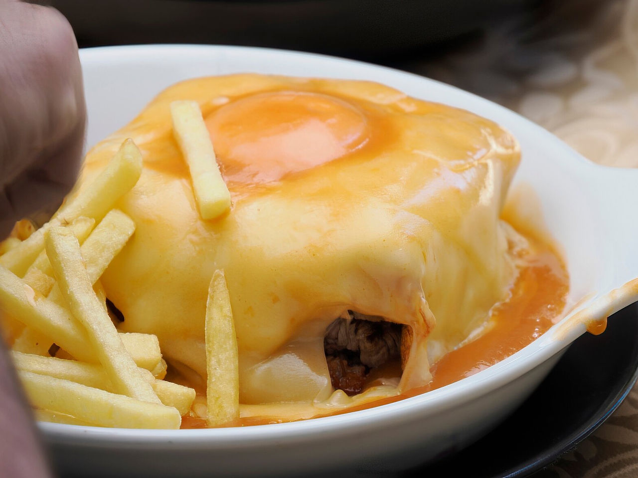 Typical Porto-style Francesinha, famous for its combination of sausages, bread, meat, and special sauce