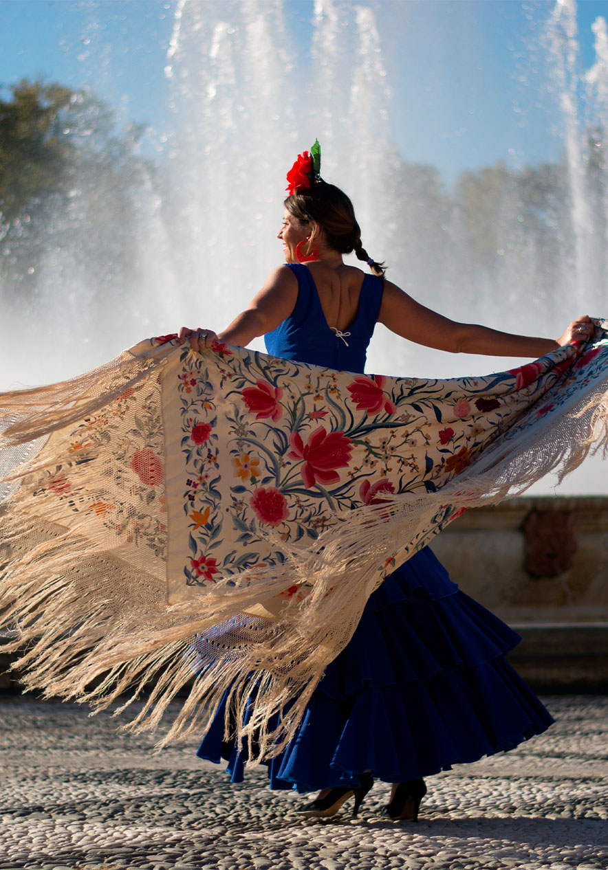 Girl dancing flamenco in front of a fountain with jets in Madrid