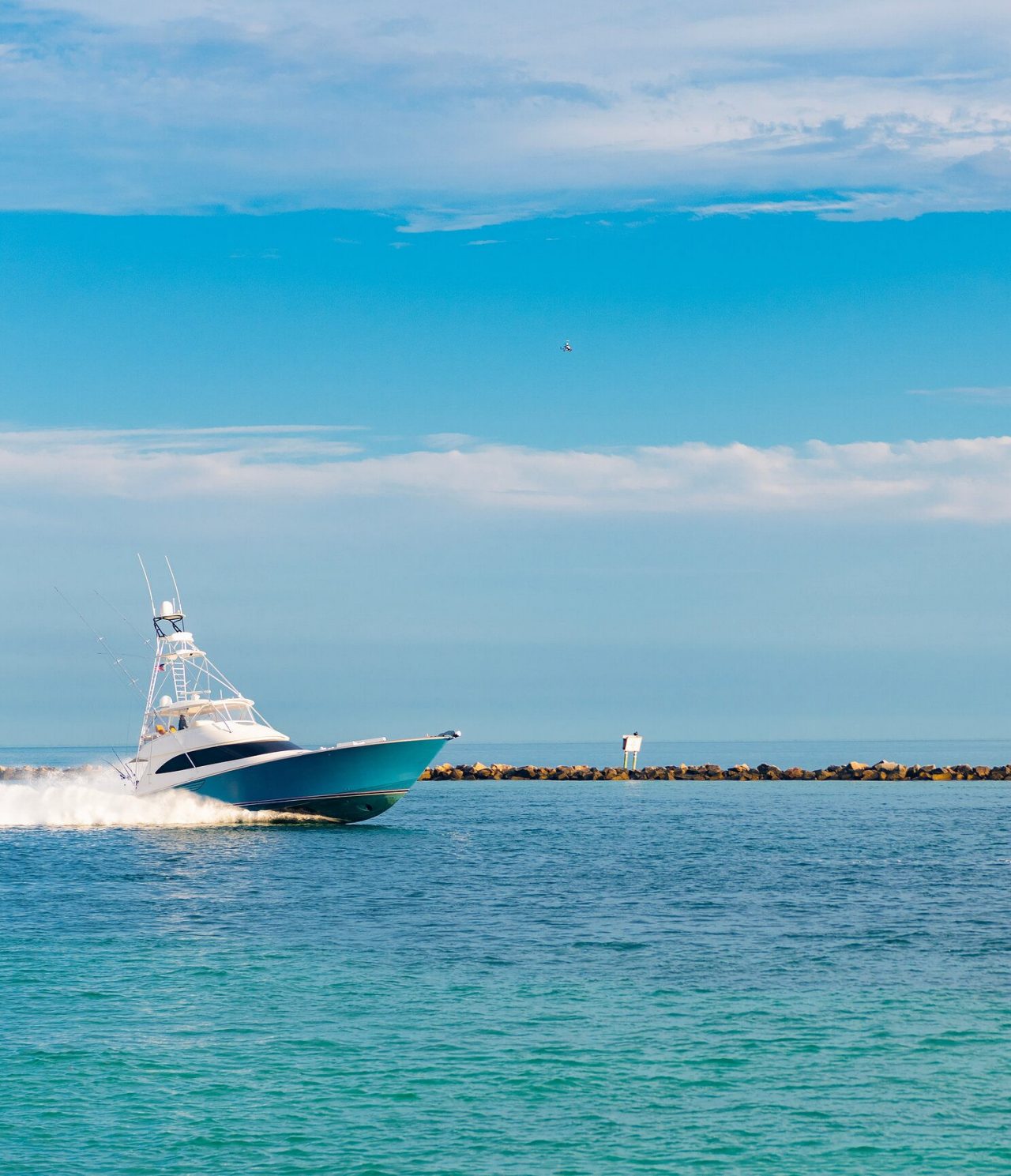 Blue and white boat entering the pier in Miami over crystal-clear blue water