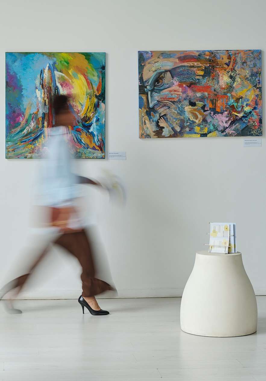 Space with art exhibits and people moving creating a dynamic atmosphere