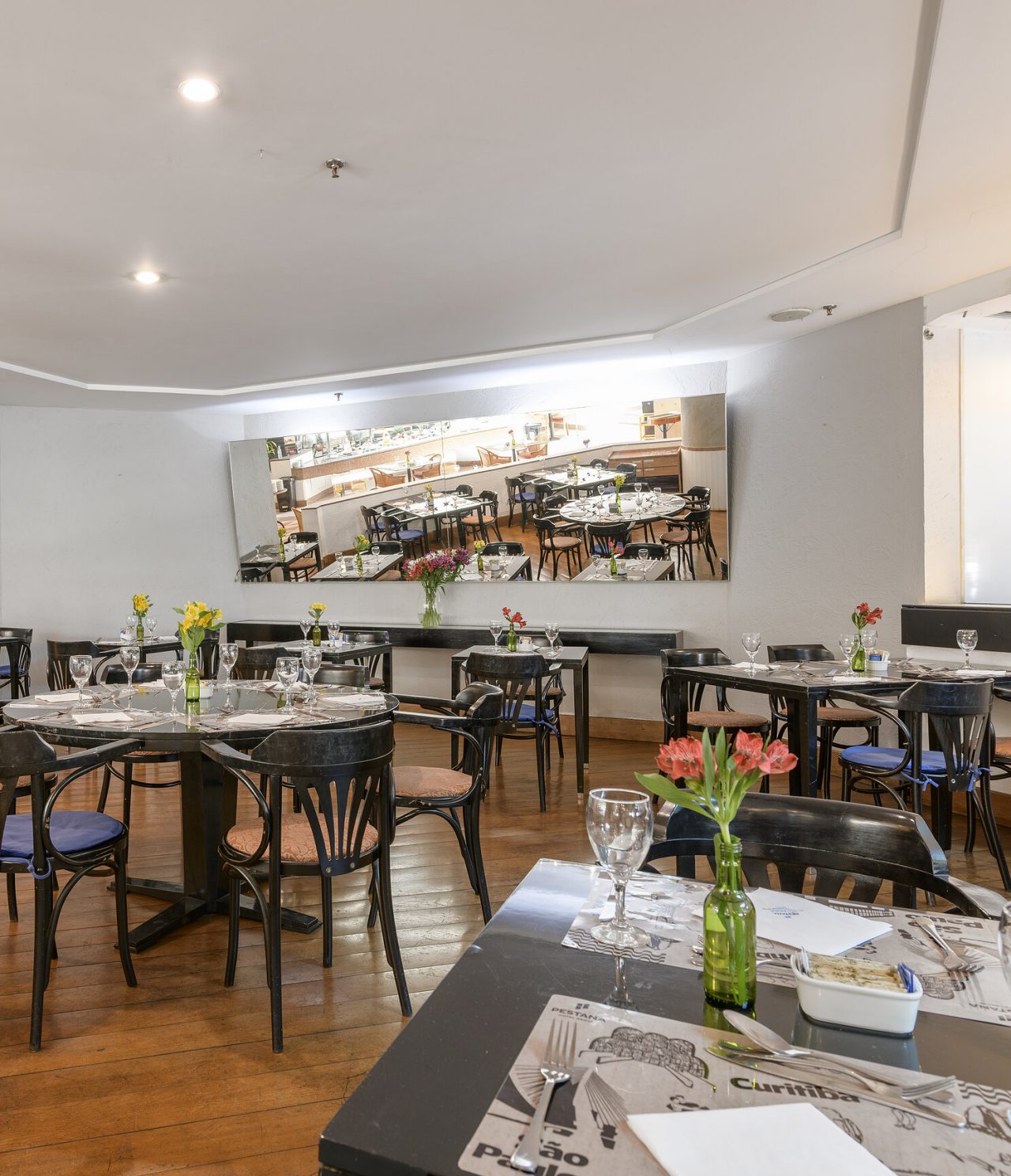 The Cais da Ribeira restaurant, at the Hotel in central São Paulo, has a spacious area with tables and chairs and a mirror